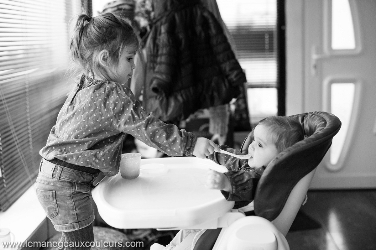 Séance photo bébé en famille photographier le quotidien commence par le repas donné par la grande soeur
