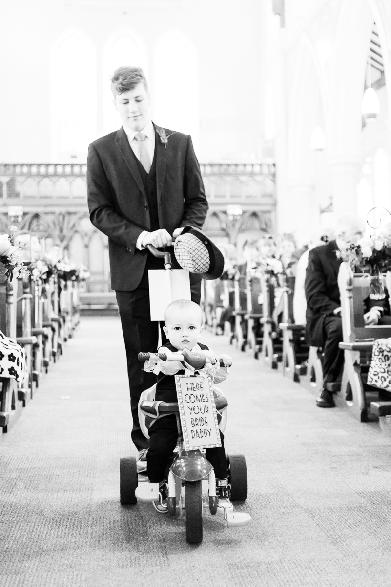 idée originale pour l'entrée de la mariée : le fils des mariés entre sur un vélo avec une pancarte "here commes you bride daddy"
