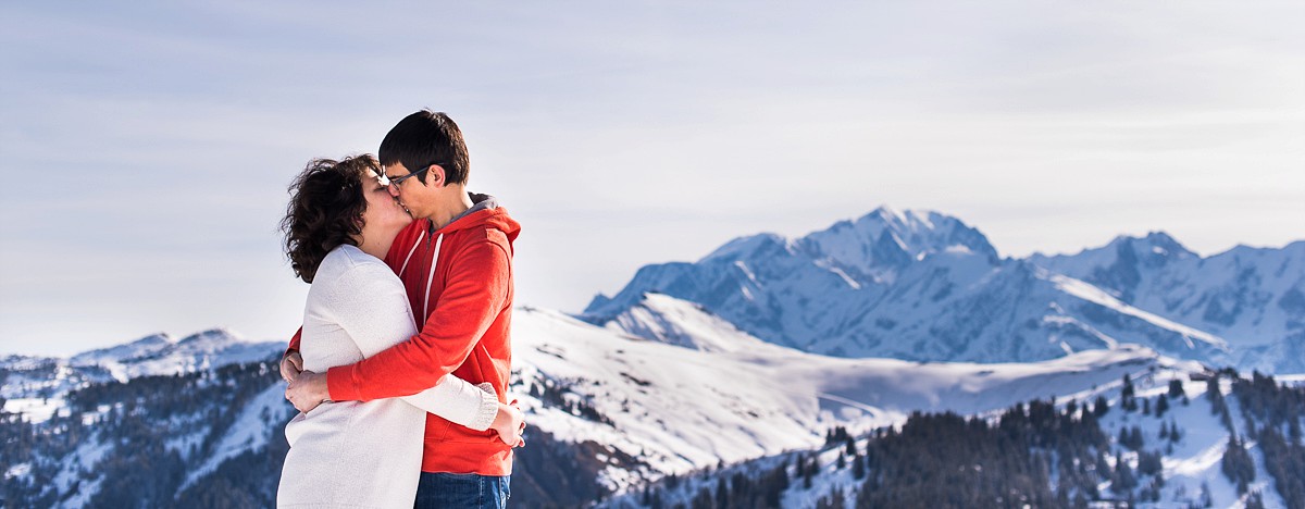 Séance photo de couple à la montagne dans la neige vue sur le mont blanc