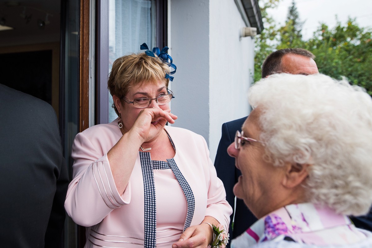 maman de la mariée qui essaye de cacher ses larmes