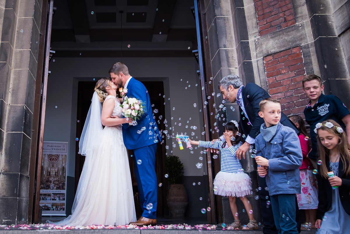 photographe mariage lambersart sortie d'église avec des bulles et des pétales de roses