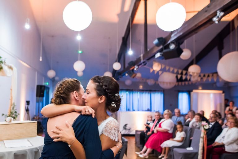 photo de mariage sur le vif pendant la ceremonie avec la mariee qui embrasse sa temoin