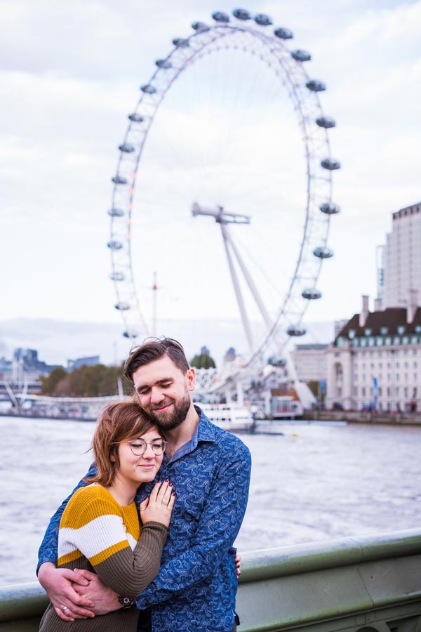 photo candide d'un couple très amoureux devant le golden eye de londres, la grand roue de Londres